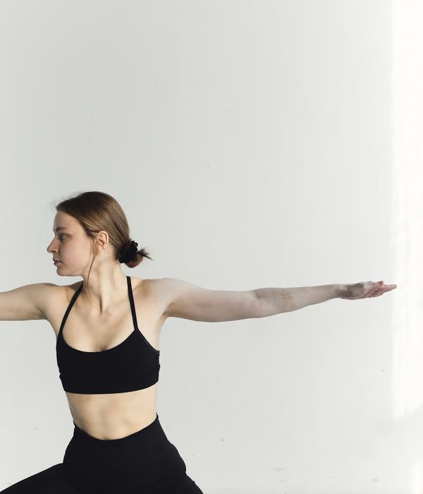 A serene woman practicing a yoga pose in a calm, modern studio.